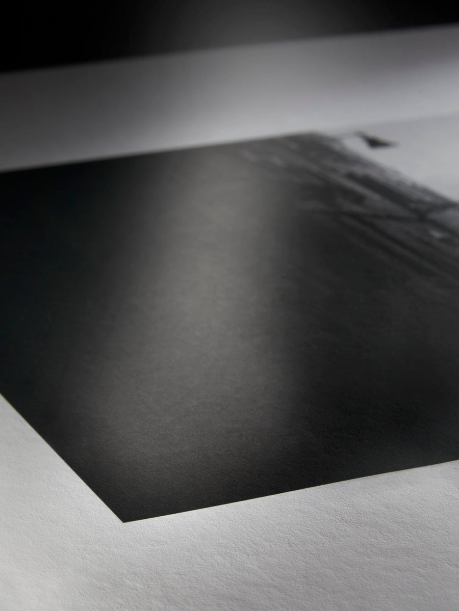 A photographer reviewing a print beside a calibrated monitor