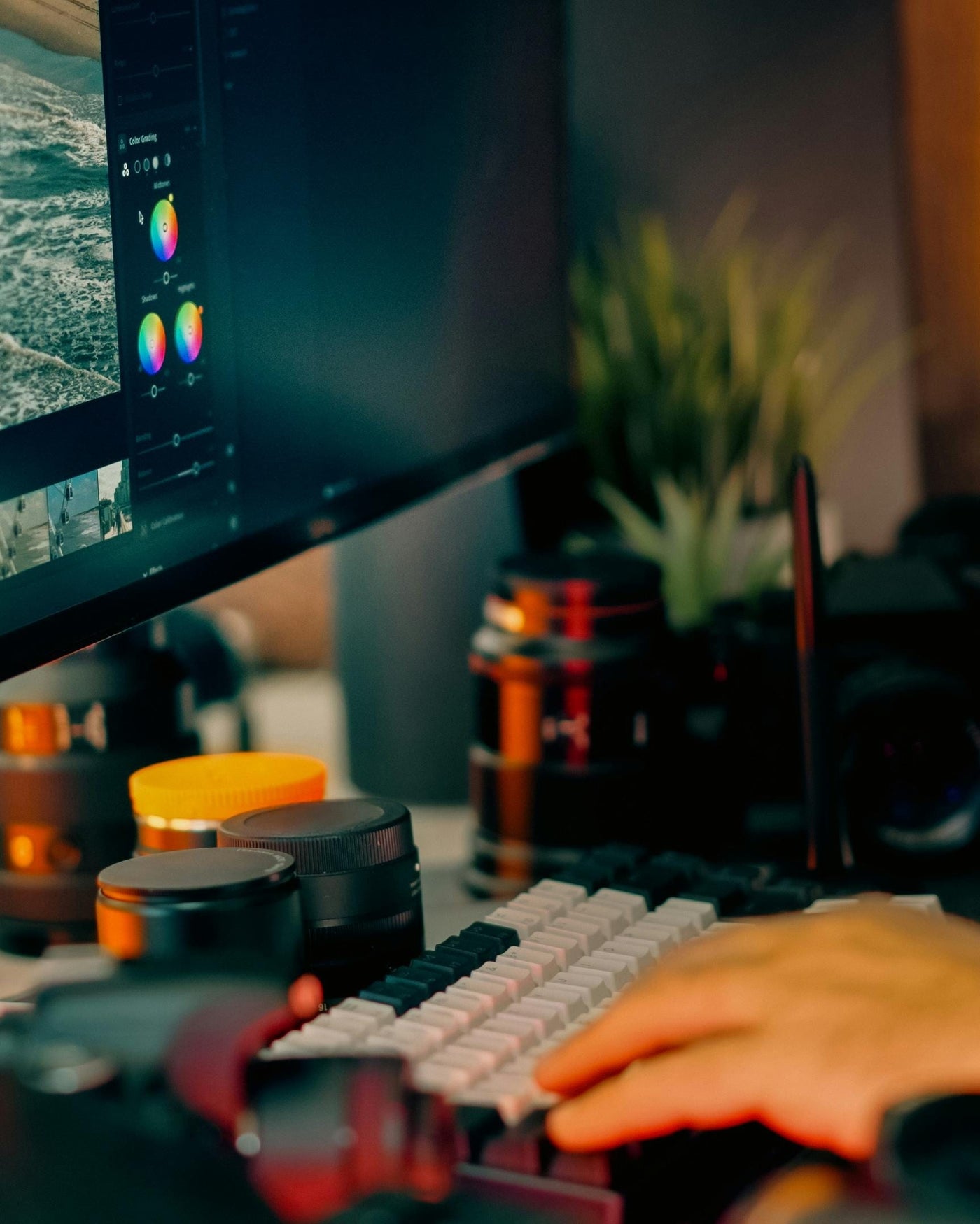 A calibrated monitor displaying a photograph beside an open photo book showing the same image