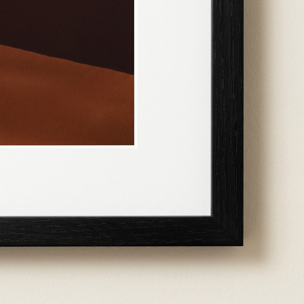 Framed abstract art with black frame on a beige wall