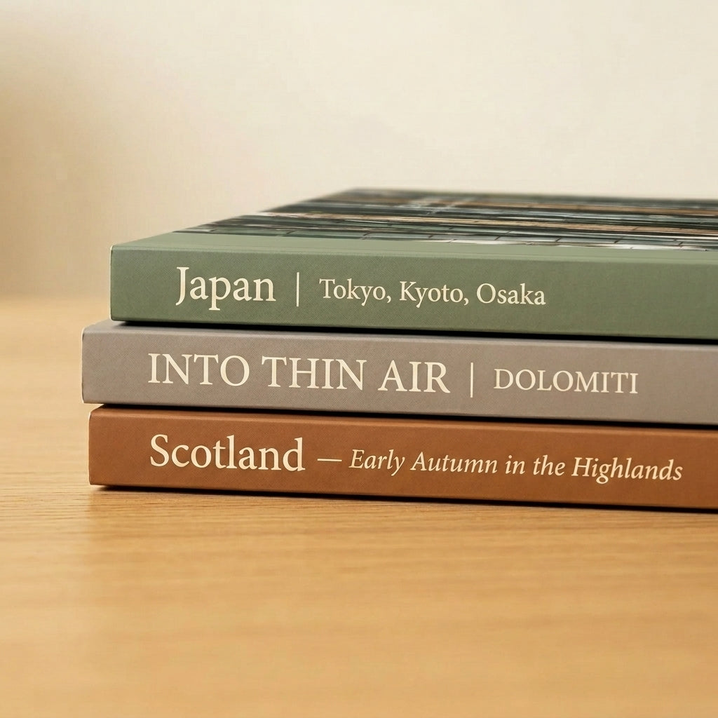 Three books titled 'Japan', 'Into Thin Air', and 'Scotland' on a wooden surface.