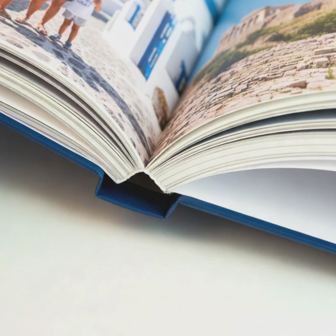 Premium Hardcover photo book being opened, showing matte cover and PUR binding